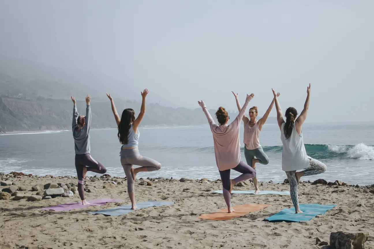 groupe de femmes faisant du yoga sur la plage